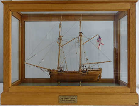 Ship model in glass case with wooden frame. Wooden model has no sails.