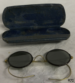 Blue hinged spectacle case is velvet lined. Spectacles have bronze metal frames