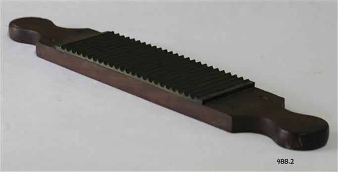 A wood and metal (brass?) flat rolling pin to make pills. 