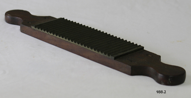 A wood and metal (brass?) flat rolling pin to make pills. 
