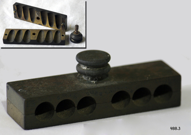 A metal mould in two parts, which is secured by a screw knob, tightening the two pieces. 