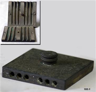 A metal mould in two parts, which is secured by a screw knob, tightening the two pieces.