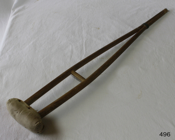 Child's wooden crutch with cushioned armpit rest,  and two wooden legs merging into one at the base. 
