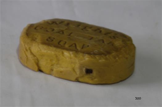 Yellow oval tablet of soap with impressed branding