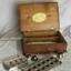 An oblong wooden box with hinged lid containing equipment for making capsules and cachets.