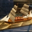 Ship is displayed on a gold plinth shaped to resemble waves