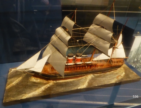 Ship is displayed on a gold plinth shaped to resemble waves