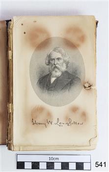 Oval line drawing of a male with light coloured hair, beard and moustache, wearing a dark jacket and vest