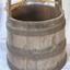 Wooden bucket made from upright planks supported by metal bands. 