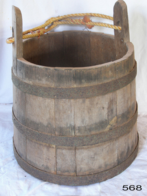 Wooden bucket made from upright planks supported by metal bands. 