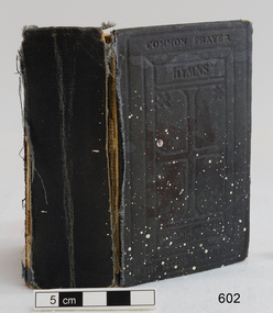Black fabric covered hardcover book's spine and front with impressed text and design.