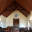 Round commemorative window installed in wall above altar in Chapel