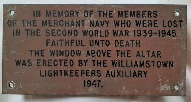 Brass plaque with text, referring to the window