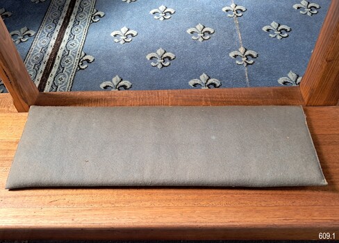 Kneeling mat on the floor beside the rail