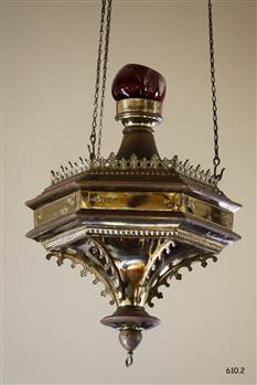Decorative round brass and glass lamp with ruby glass bowl. It is suspended on three chains.