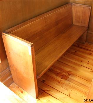 Pew is adjacent to the north wall and in the back of the row along the western wall.