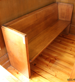 Pew is adjacent to the north wall and in the back of the row along the western wall.
