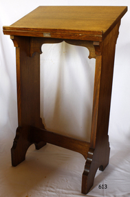 Wooden lectern with decorative brace below slanted top, and decorative finish on both legs