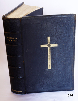 Textured black leather cover has embossed text on spine and front. The spine has five decorative horizontal lines