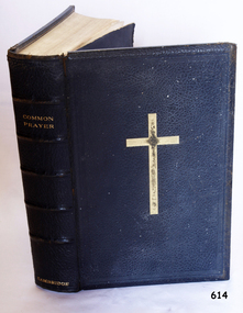 Textured black leather cover has embossed text on spine and front. The spine has five decorative horizontal lines