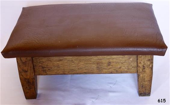 Four-legged wooden based kneeling stool with textured padded vinyl top 