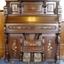 Timber organ with decorative panels and two carpet-covered foot pedals