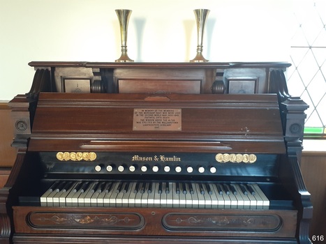Keyboard has five octaves and eleven stoppers. Gold maker's name medallions are above the keyboard.