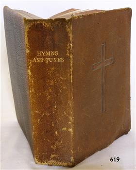 Textured brown leather cover with embossed gold text on spine, and impressed cross emblem on front