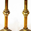 A pair of brass candlesticks with scalloped dish at top, central knob on stem and decorative base