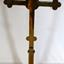 Brass cross on round base with two bulbous knobs on the stem