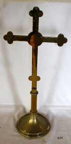 Brass cross on round base with two bulbous knobs on the stem