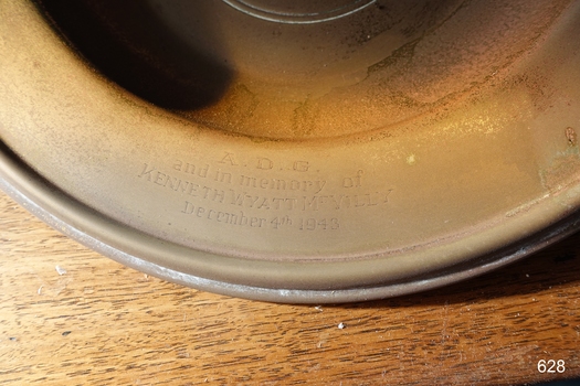 Inscription is on the lip of the plate, divided into four lines