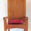 Large, tall timber armchair with inverted 'V' top on backrest and decorative cut-out design at the apex