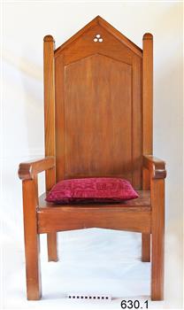 Large, tall timber armchair with inverted 'V' top on backrest and decorative cut-out design at the apex