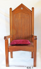 Large, tall timber armchair with inverted 'V' top on backrest and decorative cut-out design at the apex