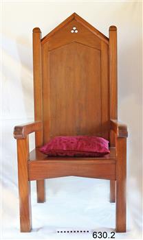 Large, tall timber armchair with inverted 'V' top on backrest and decorative cut-out design at the apex