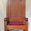 Large, tall timber armchair with inverted 'V' top on backrest and decorative cut-out design at the apex