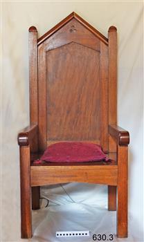 Large, tall timber armchair with inverted 'V' top on backrest and decorative cut-out design at the apex