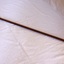 Long wooden handle with metal cap on the end.
