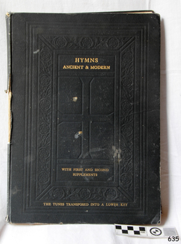 Dark hard cover has impressed pattern and gold embossing