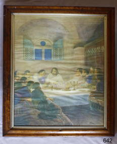 Framed print with figures indoors sitting around a table. The central figure is dressed in white.