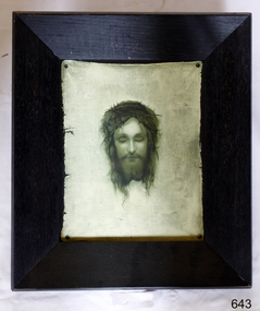Portrait of Christ-like person, printed in dark colour on light canvas-like paper, framed in a wide wooden dark frame.