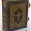 Hard cover, brown book with gold embossing and gilt page edges. Two metal clasps on open side.