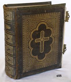 Hard cover, brown book with gold embossing and gilt page edges. Two metal clasps on open side.