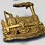 Gold coloured metal badge of a steam train engine