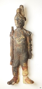Solder is made from white material, stained brown in places. Soldier is dressed in uniform and holds a gun
