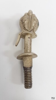 Silver coloured metal fitting with feather design on top, hook below. End has threaded fitting