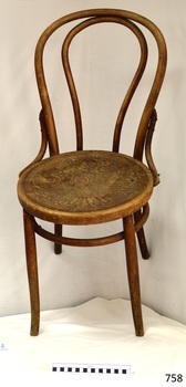 Round wooden seat has a pressed floral pattern