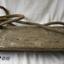 Plank of wood as seat hung from looped rope threaded through four drilled holes in corners of plank