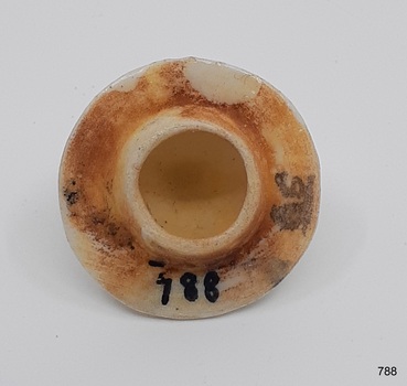 Round white ceramic lid with rough surface under glaze. Hollow inside.